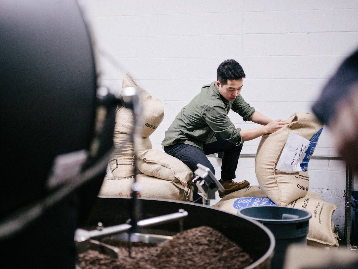 Unloading sacks of green coffee beside the roaster at the Elysian roastery