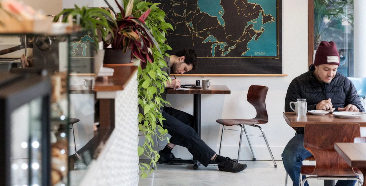 Inside the Elysian cafe at Burrard & Helmcken, with plants and a large wall map