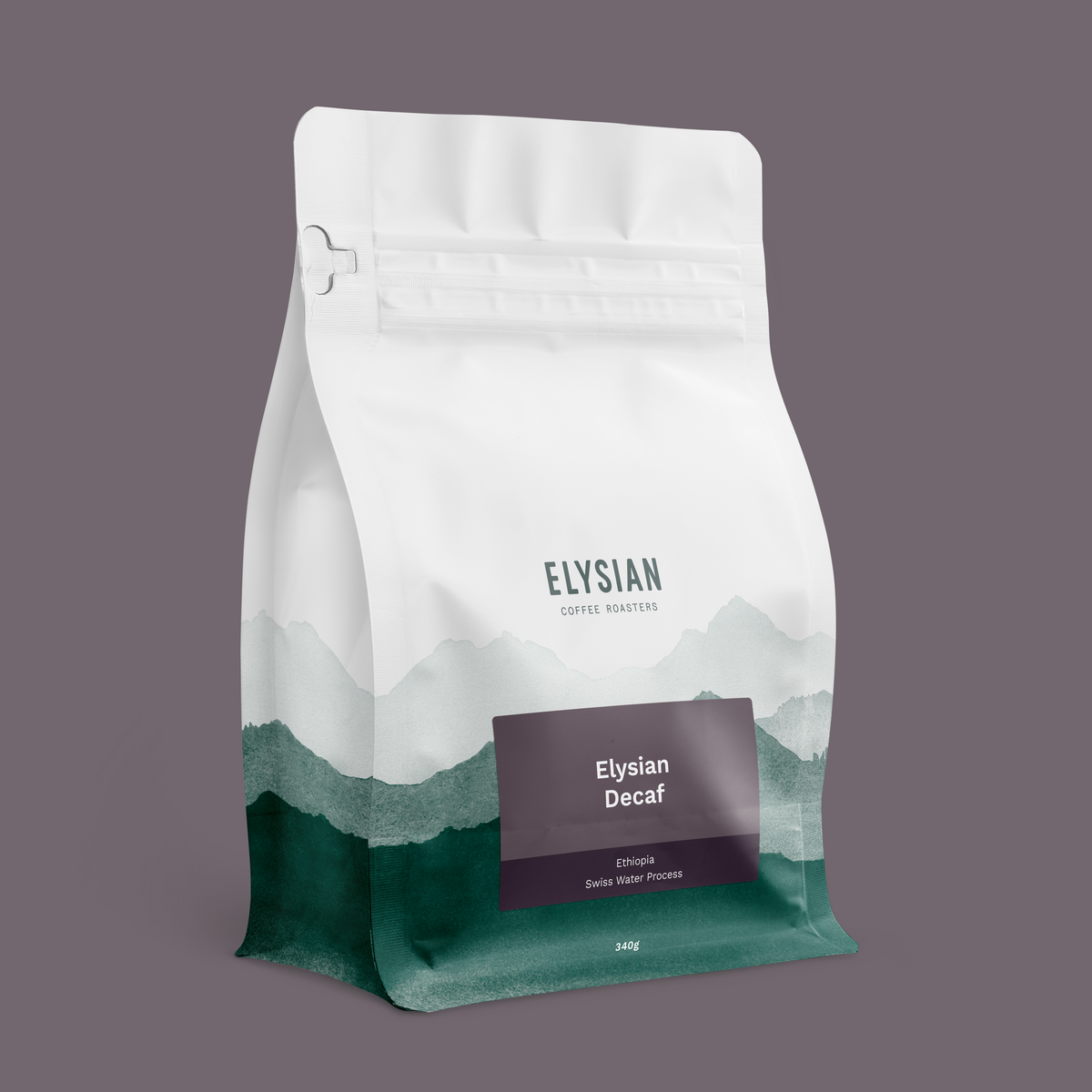 Elysian Decaf coffee bag, white with painted green mountains, on a muted purple background